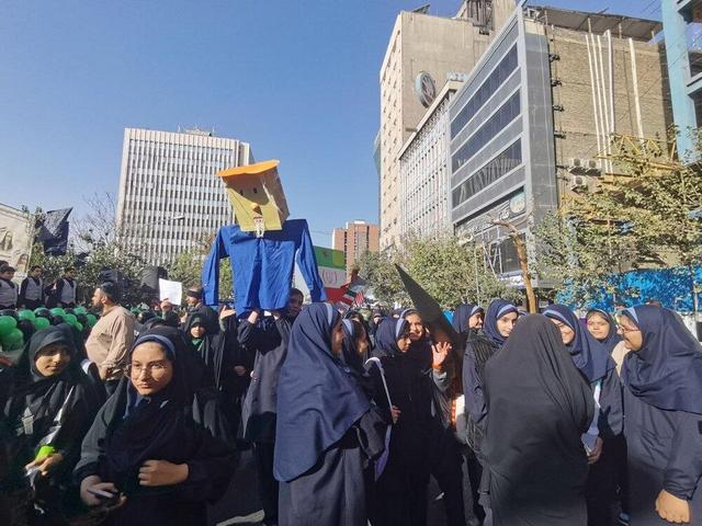 آدمک ترامپ در دست دانش‌آموزان شرکت کننده در راهپیمایی ۱۳ آبان