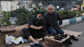 پیرمردی که با قوت دستانش در پیاده‌روی اربعین است